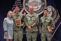 Vice Adm. Brendan McLane, commander, Naval Surface Force, U.S. Pacific Fleet, stands with Lt. Potter Seibels, winner of the Shiphandler of the Year Award, and his mother, Hallie Seibels (left), and L.t. j.g. Jake Chalenko (right), runner up in the Shiphandler of the Year Award, Surface Warfare Schools Command headquarters, Naval Station Newport, R.I., July 15, 2025.
