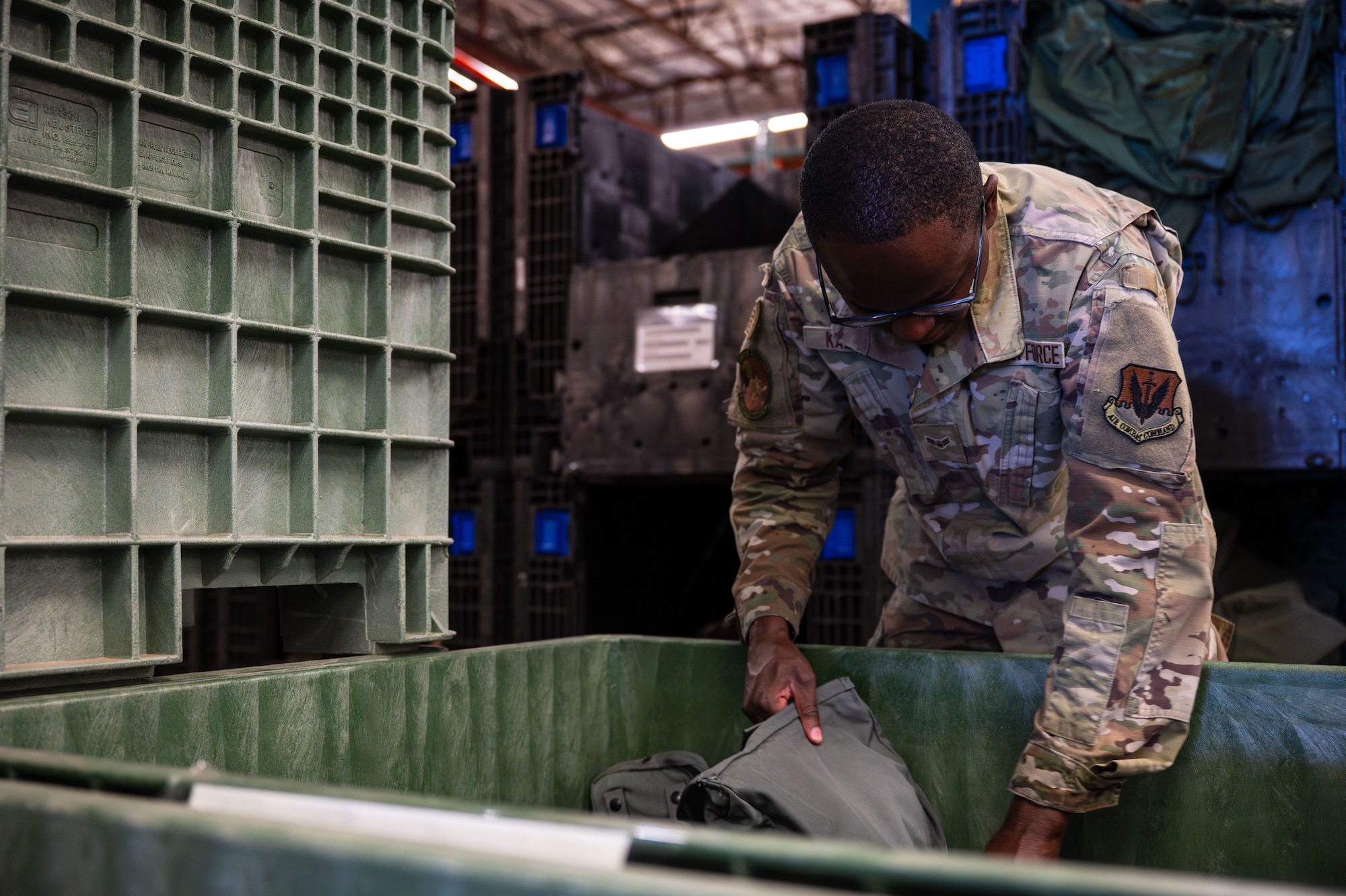 U.S. Air Force Airman 1st Class Steven Kalonga, 355th Logistics Readiness Squadron material manager, grabs a gas mask at Davis-Monthan Air Force Base, Arizona, July 22, 2025. LRS Airmen ensure the correct gear is issued to members tasked for deployments and temporary duty. (U.S. Air Force photo by Senior Airman Jasmyne Bridgers-Matos)
