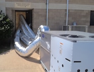 An air conditioning unti pushing air into a building.