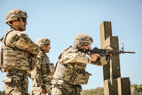 Soldiers firing weapons on a training range.