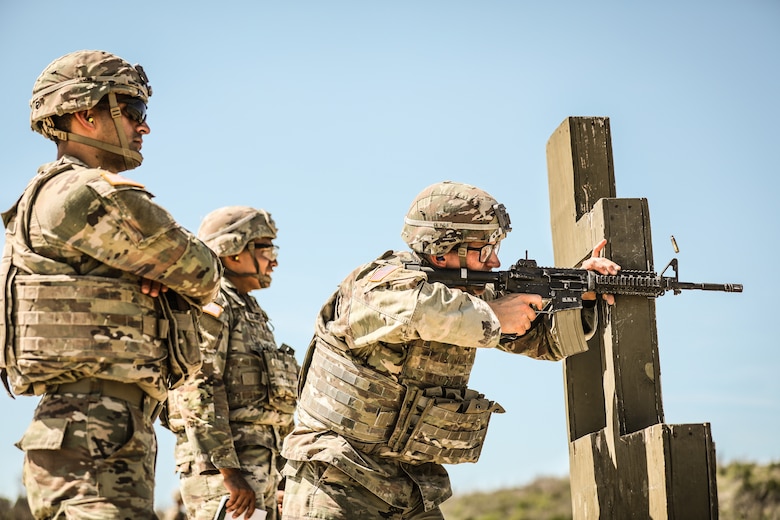 Soldiers firing weapons on a training range.