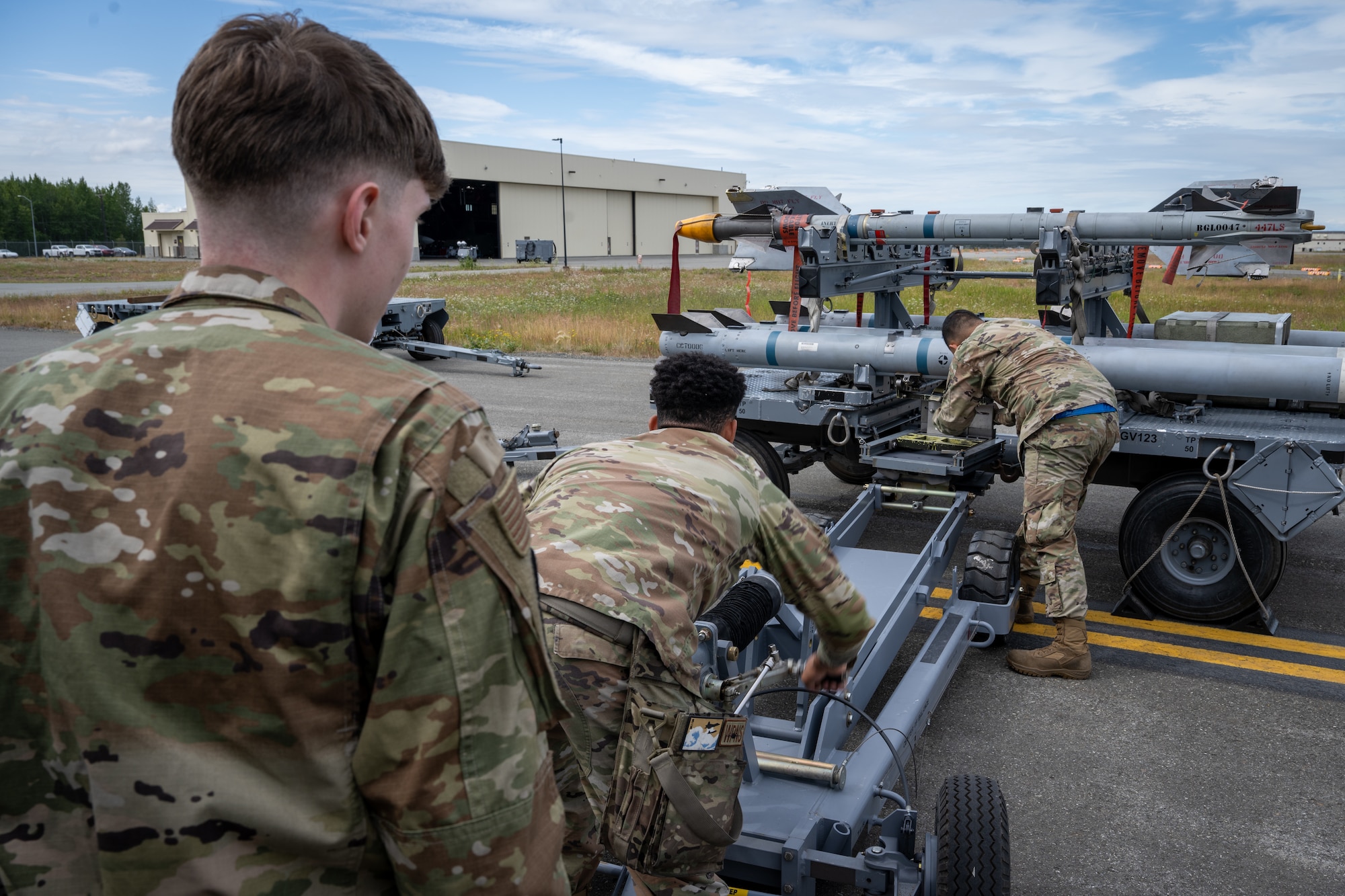 U.S. Air Force Airmen assigned to the 525th Fighter Generation Squadron load munitions onto a weapons loader during the second quarter mission generation competition at Joint Base Elmendorf-Richardson, Alaska, July 18, 2025.