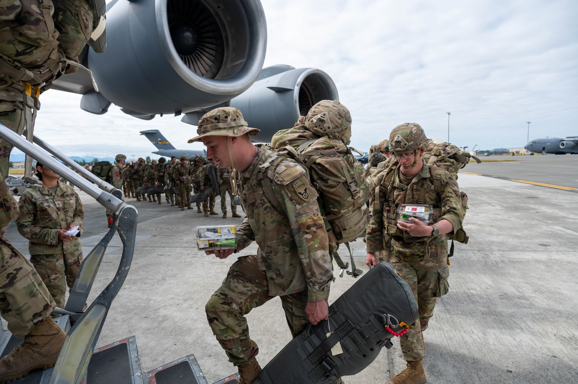 Soldier enter a C-17 from a side door.