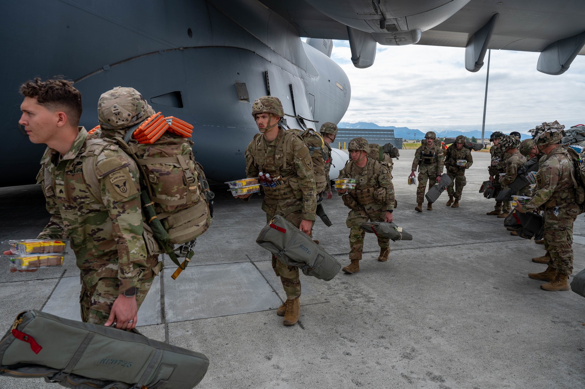 Soldiers enter a C-17 from a side door.
