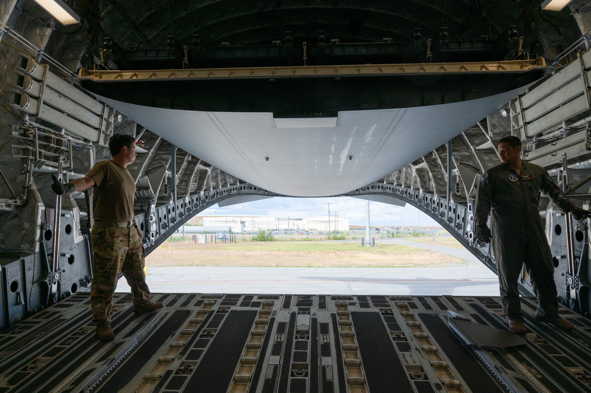 Airmen open a C-17 ramp while on the flightline.
