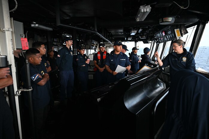 Able Seaman from the Republic of the Marshall Islands (RMI) Sea Patrol and U.S. Coast Guard members assigned to the Legend-class U.S. Coast Guard Cutter Stratton (WMSL 752) conduct a brief on Stratton’s bridge prior to a fisheries boarding in the RMI’s exclusive economic zone, July 10, 2025.