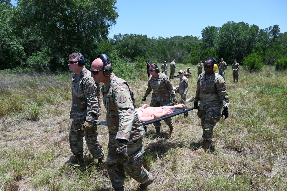 Senior Airman John Hall, center left, 26th Aerial Port Squadron aerial port specialist, helps with a litter carry alongside fellow Airmen during a simulated Army medevac during OPERATION DUSTOFF VIGILANCE ’25 at Joint Base San Antonio-Camp Bullis, Texas, July 16, 2025.