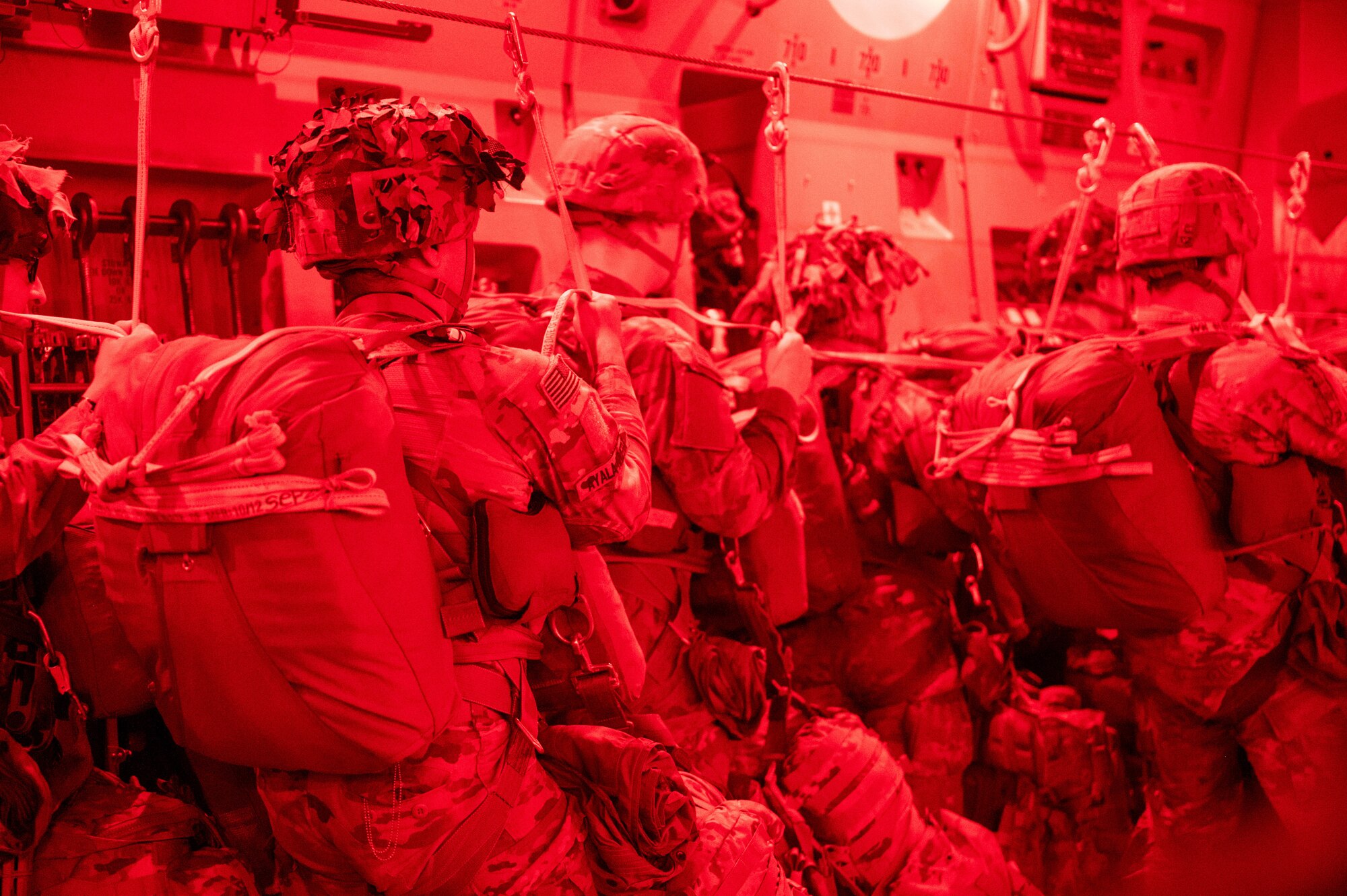Paratroopers ready to jump outside of a C-17. Red photo.
