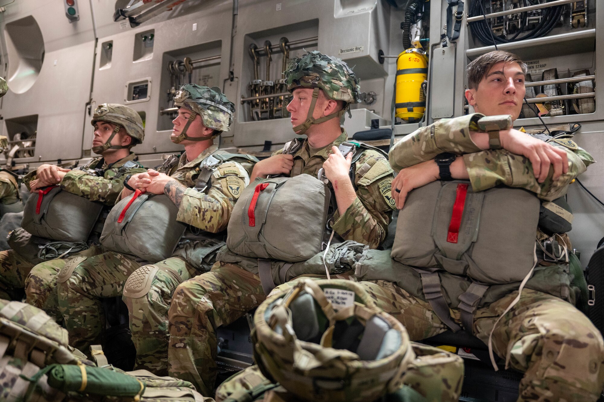 Soldiers gathered in a C-17 sitting in chairs.