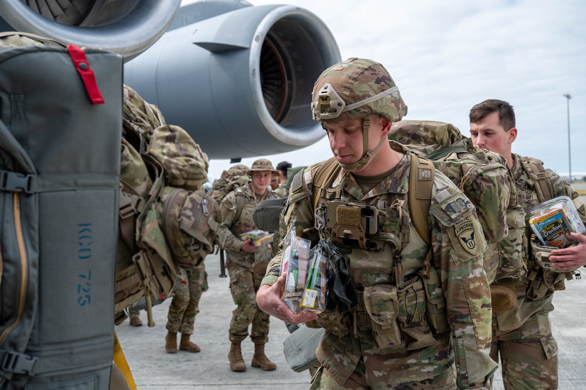 Soldiers enter a C-17 from a side door.