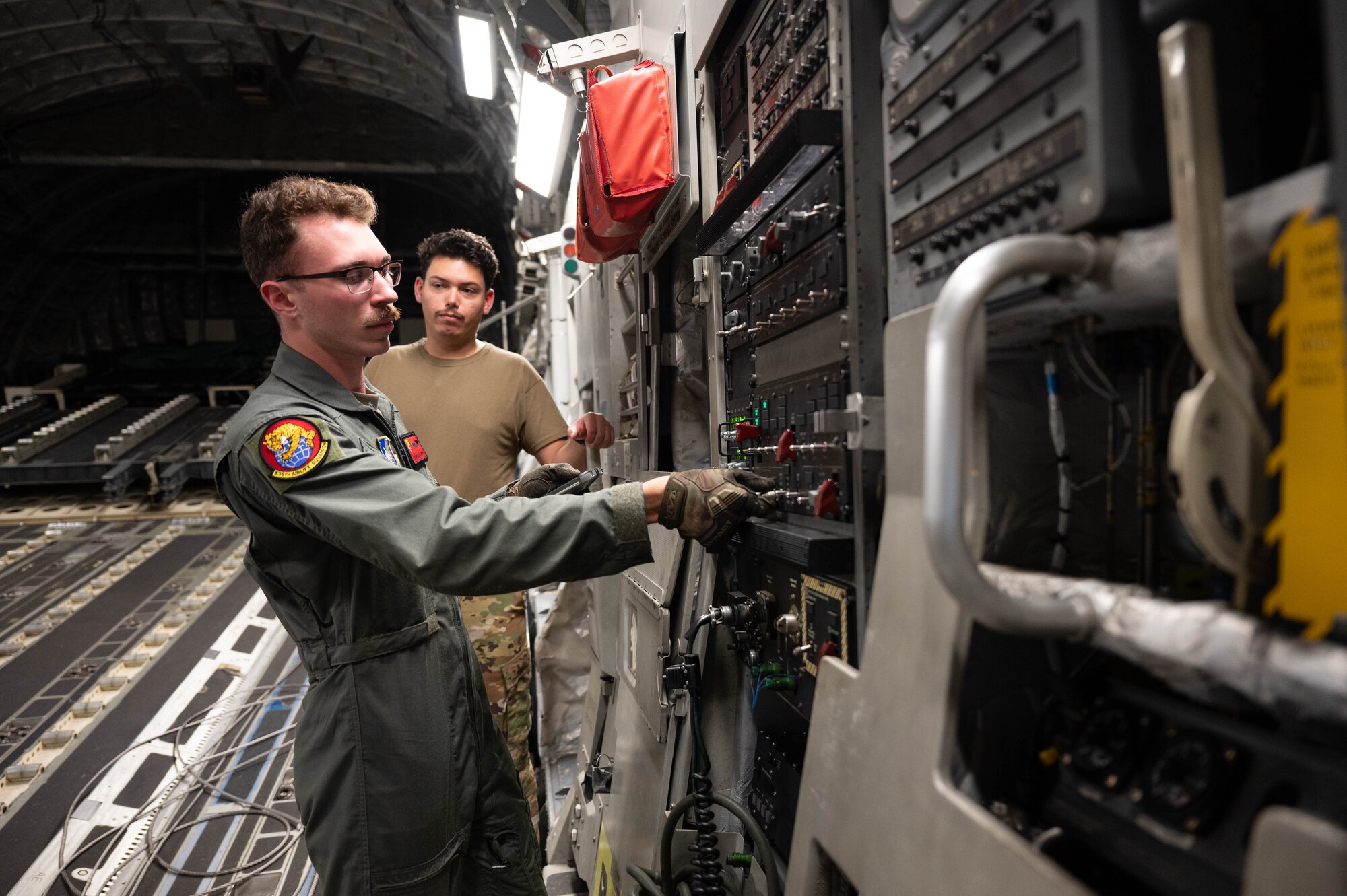 Airmen conducting safety checks while inside of a C-17.