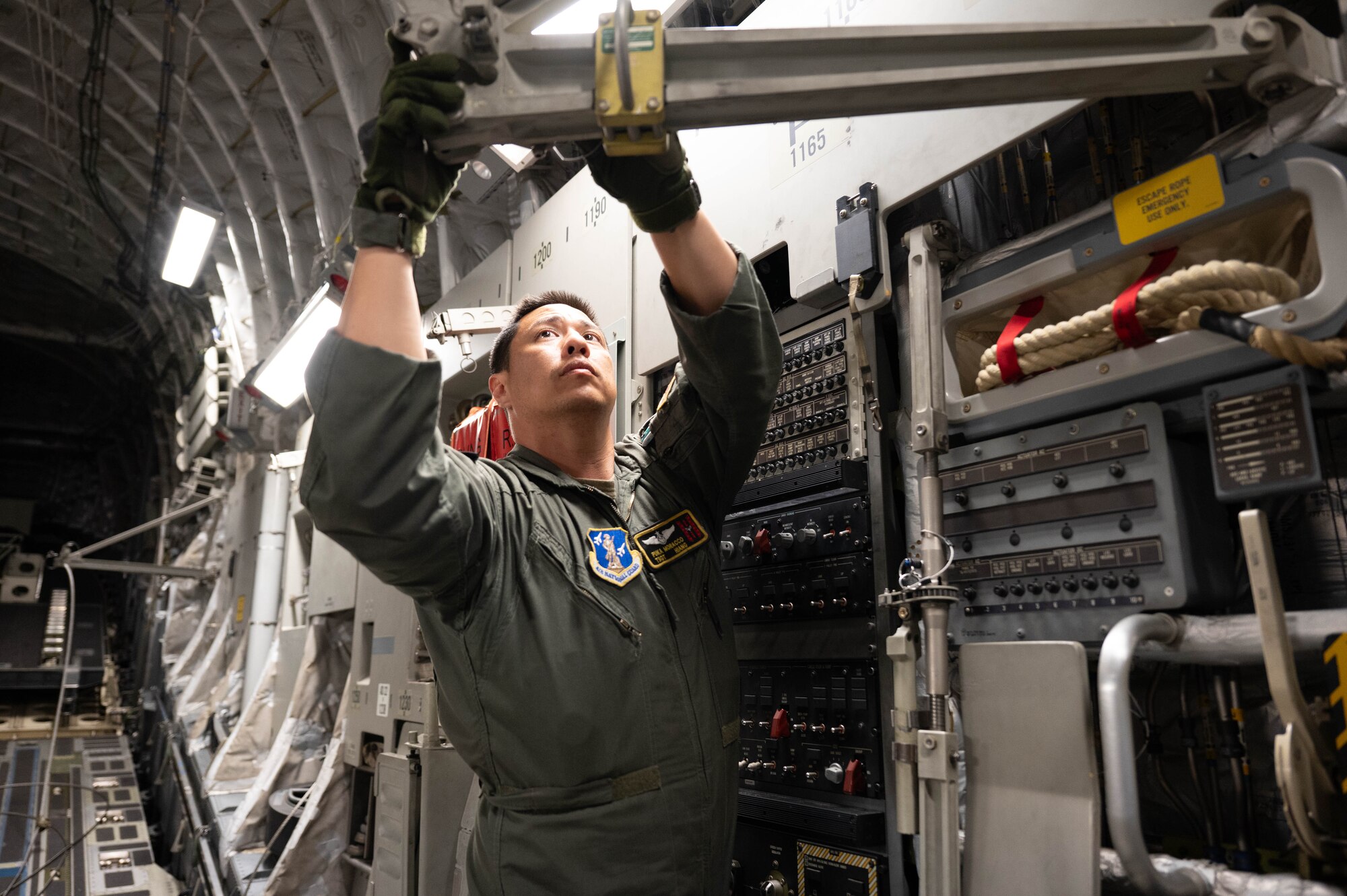 An Airman preparing a C-17 for paratroopers.