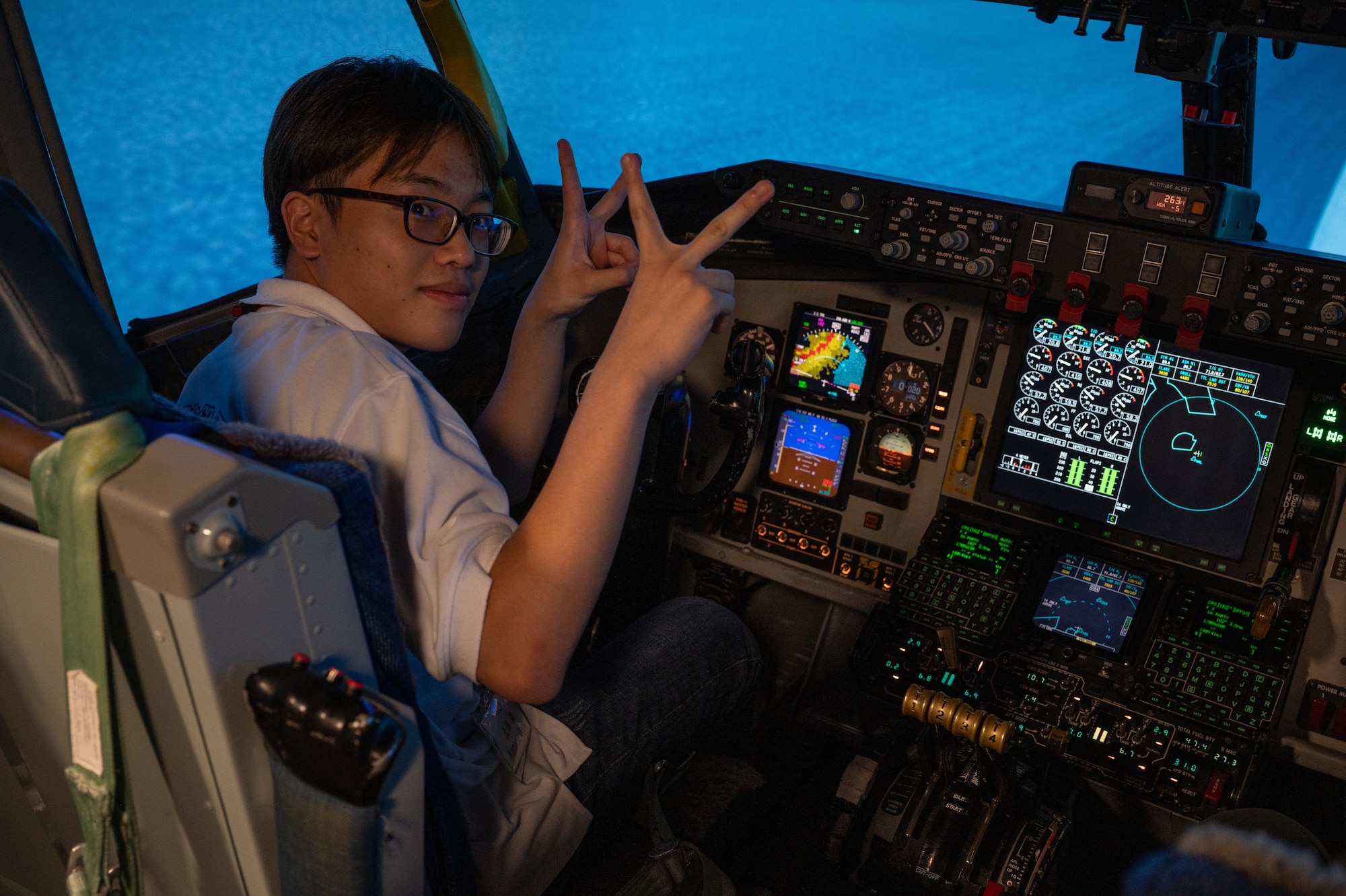 A KLI student posing for a photo inside of a KC-135 Stratotanker flight simulator