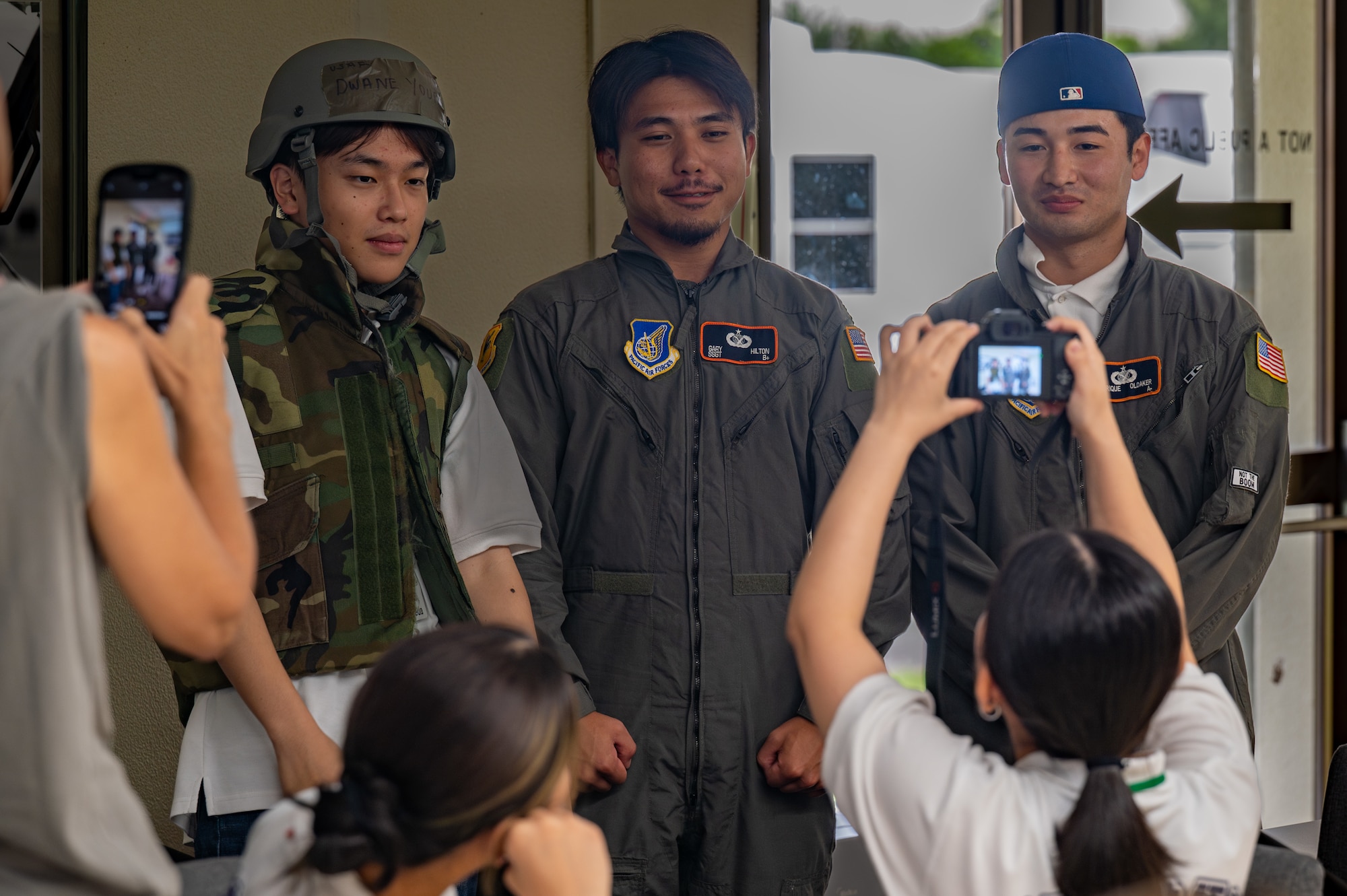 Three KLI students pose for a photo while wearing military gear