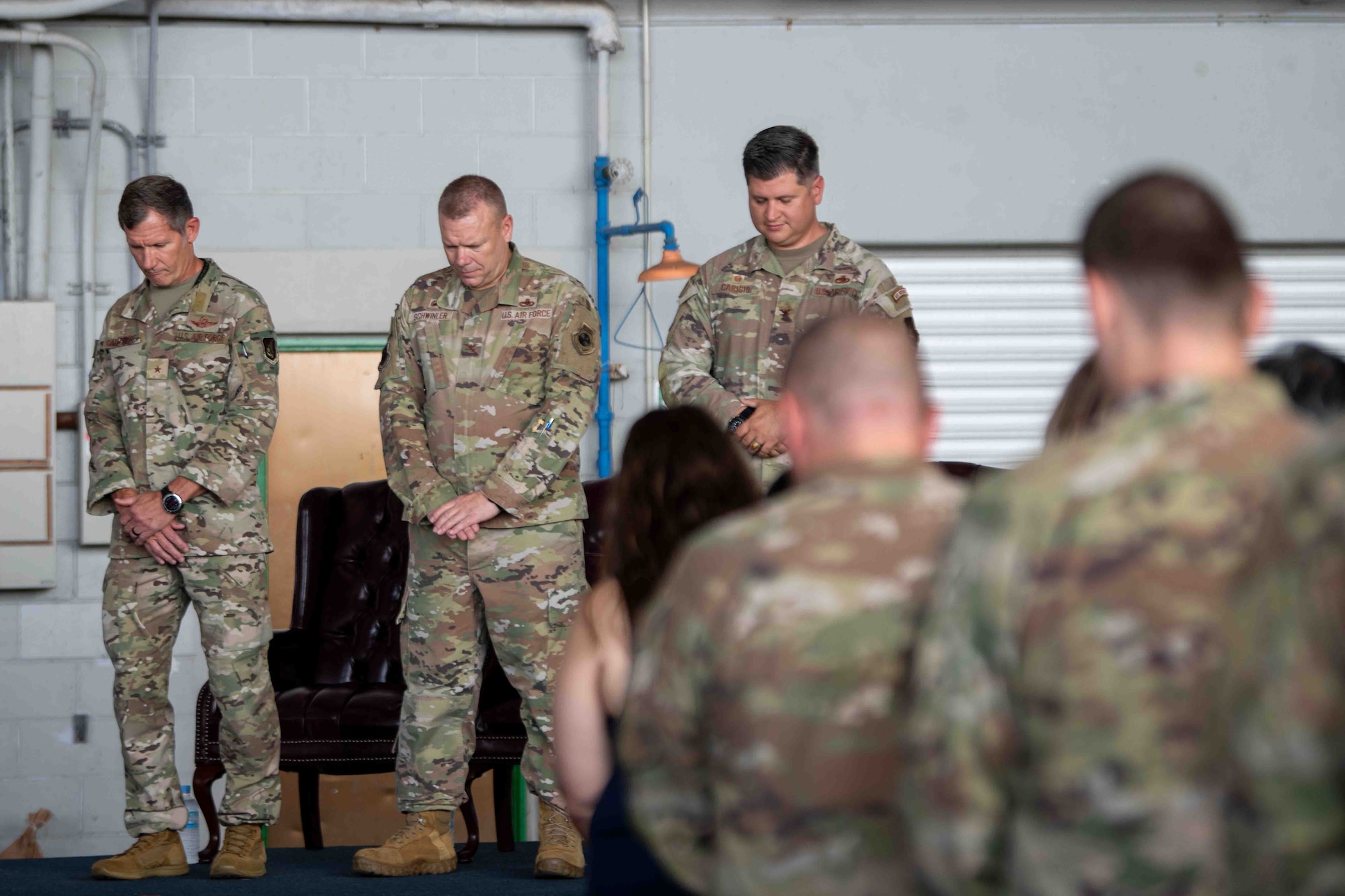 military members look down during invocation