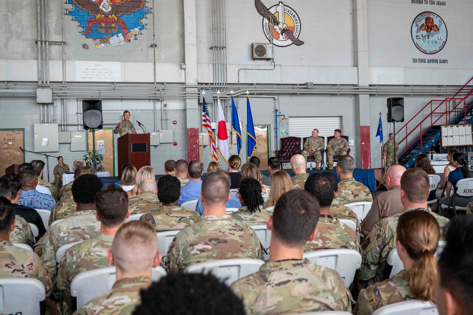 military member gives speech on podium in front of a crowd