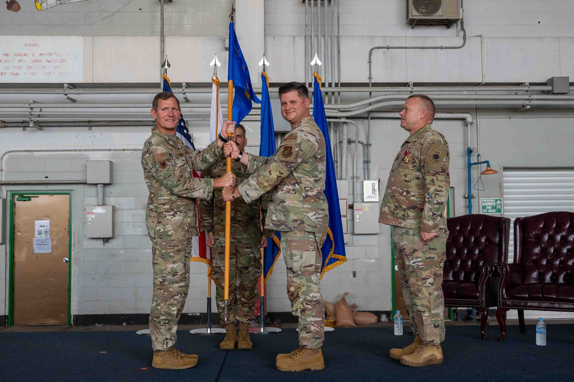 military members hold the guidon during ceremony