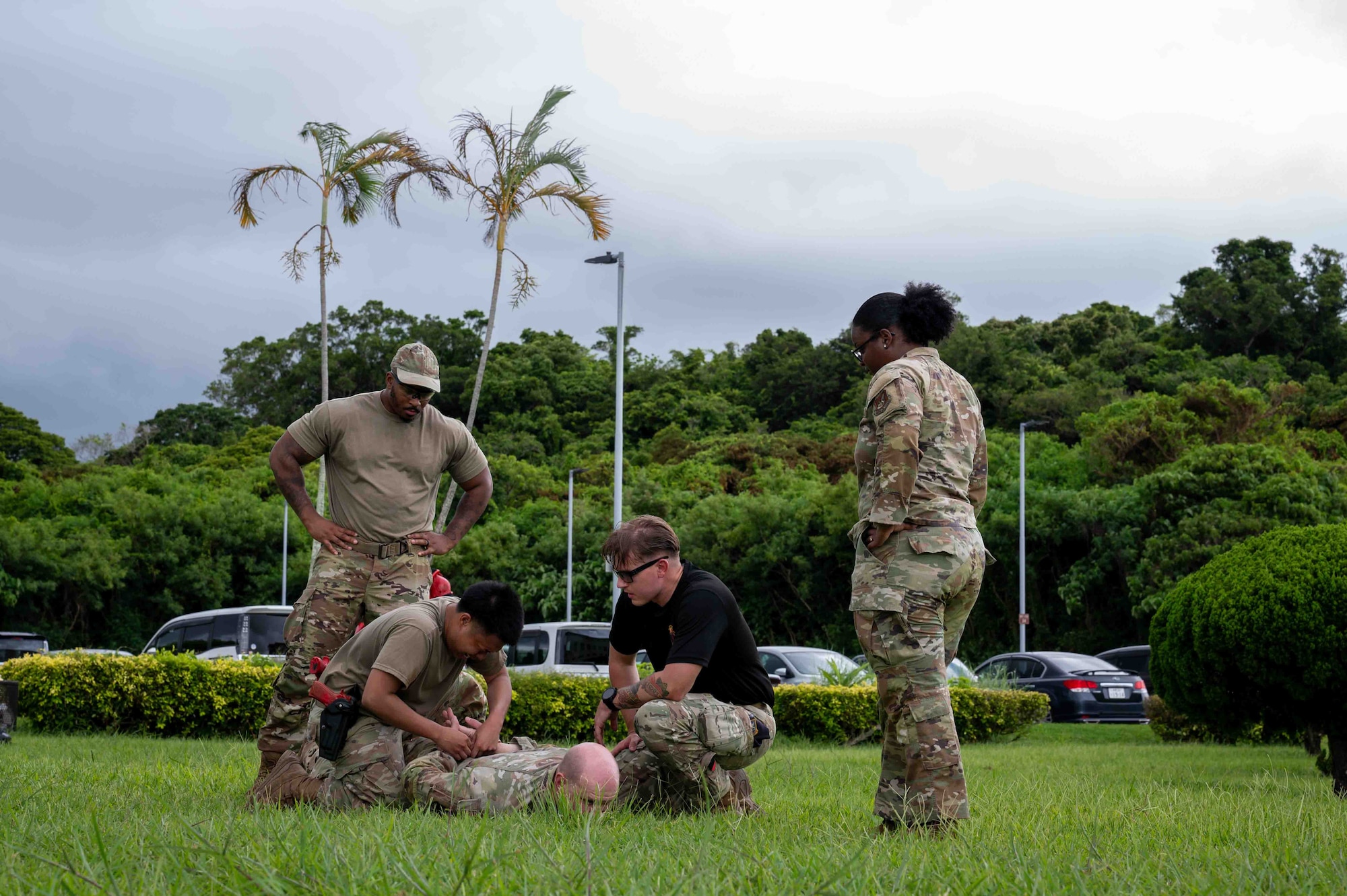military members handcuffs suspect during training and is getting observed by other people