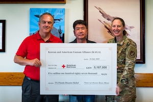 Brian Murnahan, American Red Cross Service to the Armed Forces Korea region regional program director, and U.S. Air Force Col. Kathryn "Wolf" Gaetke, 8th Fighter Wing commander, accept a donation for Texas flood relief efforts from Choi In-t’ae, Korean-American Gunsan Alliance chairman