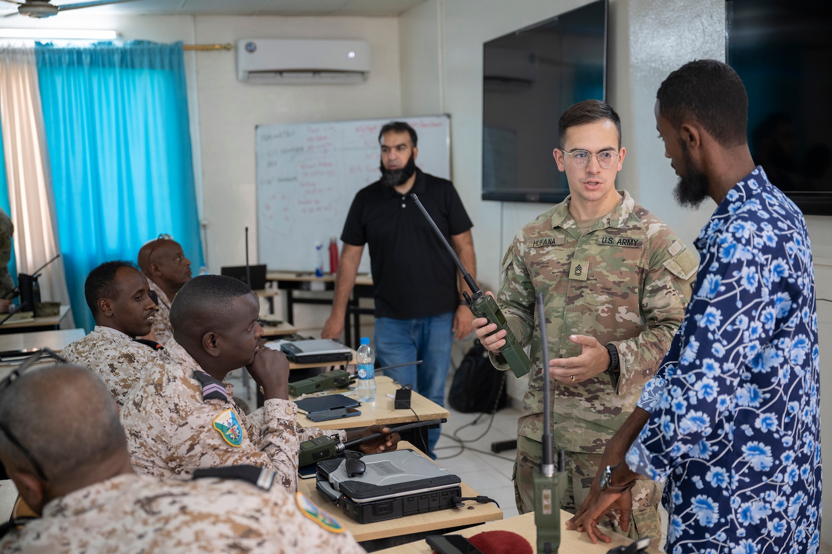 U.S. Army Sgt. 1st Class Garrett Hufana, center, information technology specialist with the 149th Maneuver Enhancement Brigade, Kentucky Army National Guard, participates in a radio communications knowledge exchange with Djiboutian soldiers at the Djiboutian signal corps compound in Djibouti City, Djibouti, July 14, 2025.
