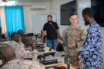 U.S. Army Sgt. 1st Class Garrett Hufana, center, information technology specialist with the 149th Maneuver Enhancement Brigade, Kentucky Army National Guard, participates in a radio communications knowledge exchange with Djiboutian soldiers at the Djiboutian signal corps compound in Djibouti City, Djibouti, July 14, 2025.