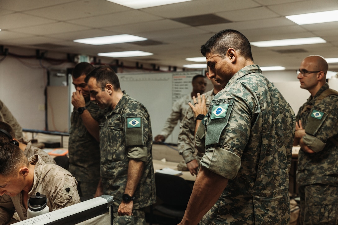 Corpo de Fuzileiros Navais (Brazilian Marine Corps ) marines observe U.S. Marines with Tactical Training and Exercise Control Group, Marine Air Ground Task Force Training Command, Marine Corps Air Ground Combat Center, as they operate a Fire Support Team Exercise during  Service Level Training Exercise 4-25 on Camp Wilson, Twentynine Palms, California, July 17, 2025. The Brazilian Marines were part of a delegation that visited to observe the SLTE process, designed, enabled, and overseen by the Tactical Training and Exercise Control Group, in order to improve their own standard operating procedures and increase operability with their U.S. partners. (U.S. Marine Corps photo by LCpl Dominic Spence)