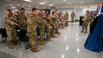 Service members stand and replace their patches with new ones.
