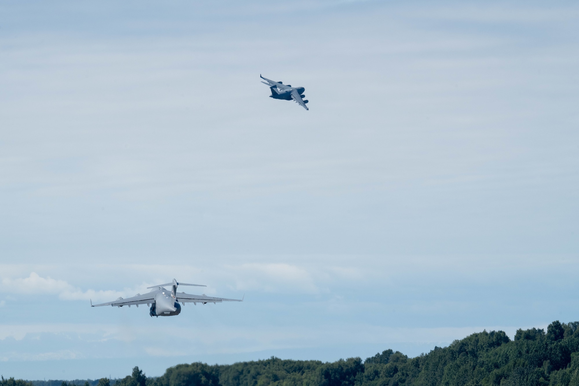 U.S. Air Force C-17 Globemaster III aircraft assigned to the 437th Airlift Wing, top, and the 155th Airlift Squadron, Tennessee Air National Guard, take off in support of exercise Resolute Force Pacific on Joint Base Elmendorf-Richardson, Alaska, July 13, 2025.