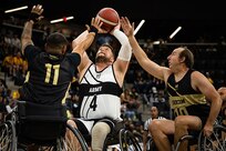 U.S. Army Sgt. 1st Class Adam Proctor shoots over two Team SOCOM defenders during the wheelchair basketball gold medal game at the 2025 Department of Defense Warrior Games in Colorado Springs Colorado, July 20, 2025.