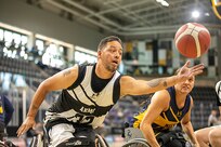 U.S. Army Retired Spc. Anthony Farve stretches for a loose ball during a wheelchair basketball game at the 2025 Department of Defense Warrior Games in Ed Robson Arena, Colorado Springs, Colorado, July 20, 2025.