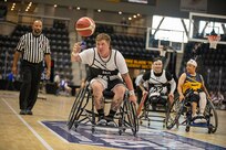 U.S. Army Staff Sgt. Tyler Pollard reaches for a loose ball during a wheelchair basketball game at the 2025 Department of Defense Warrior Games in Ed Robson Arena, Colorado Springs, Colorado, July 20, 2025.