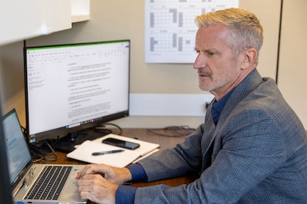 Stede Harwood, U.S. Army Financial Management Command financial management systems analyst, works at his desk in the Maj. Gen. Emmett J. Bean Federal Center in Indianapolis July 23, 2025. For his efforts in keeping the Army’s Deployed Disbursing System in balance, Harwood was recently named a U.S. Army Materiel Command employee of the quarter for the first quarter of Fiscal Year 2025. (U.S. Army photo by Mark R. W. Orders-Woempner)