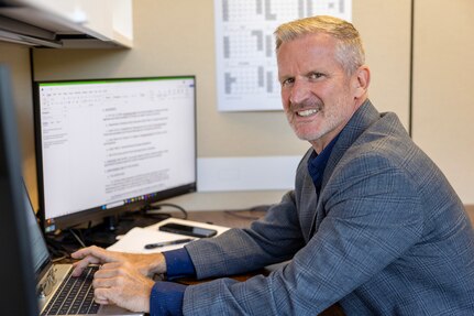 Stede Harwood, U.S. Army Financial Management Command financial management systems analyst, poses for a photo at his desk in the Maj. Gen. Emmett J. Bean Federal Center in Indianapolis July 23, 2025. For his efforts in keeping the Army’s Deployed Disbursing System in balance, Harwood was recently named a U.S. Army Materiel Command employee of the quarter for the first quarter of Fiscal Year 2025. (U.S. Army photo by Mark R. W. Orders-Woempner)