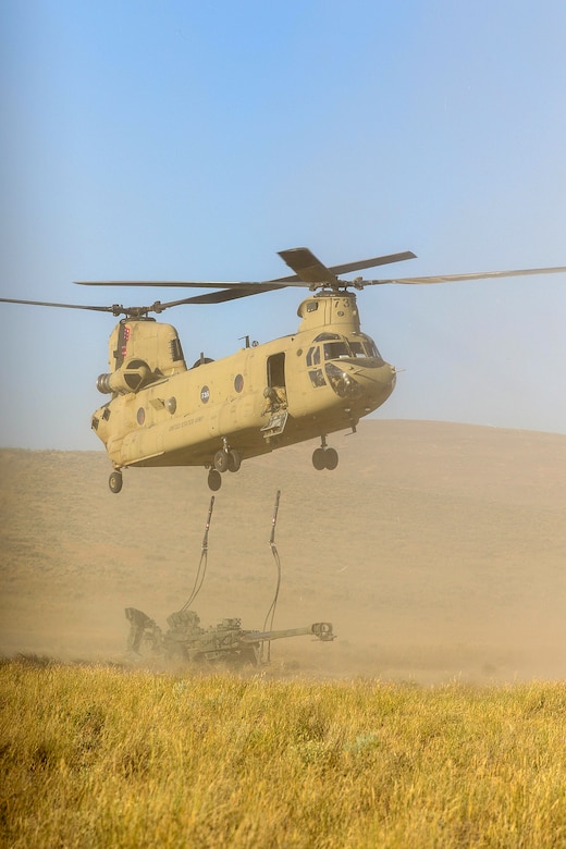 A Chinook Helicopter lifts an artillery piece during the Raven Focus exercise at Yakima Training Center, July 16, 2025. Active duty, U.S. Army Reserve and National Guard Soldiers participated in the training exercise to increase readiness for potential real-world deployments.