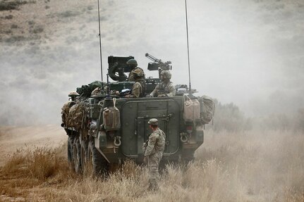An observer coach/trainer, assigned to the 189th Combined Arms Training Brigade, stands by a Stryker vehicle preparing to move to a new position during the Raven Focus exercise, July 20, 2025, at the Yakima Training Center in Washington.