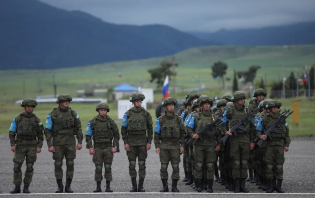 Russian service members in uniform stand in a line while attending a base-closing ceremony in Khojaly, Azerbaijan.