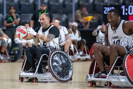 U.S. Army Cpt. Carlos Rivera, left, catches the ball next to Master Sgt. Earlie Brown in a wheelchair rugby match during the 2025 Department of Defense Warrior Games at Ed Robson Arena, Colorado Springs, Colorado, July 22, 2025.