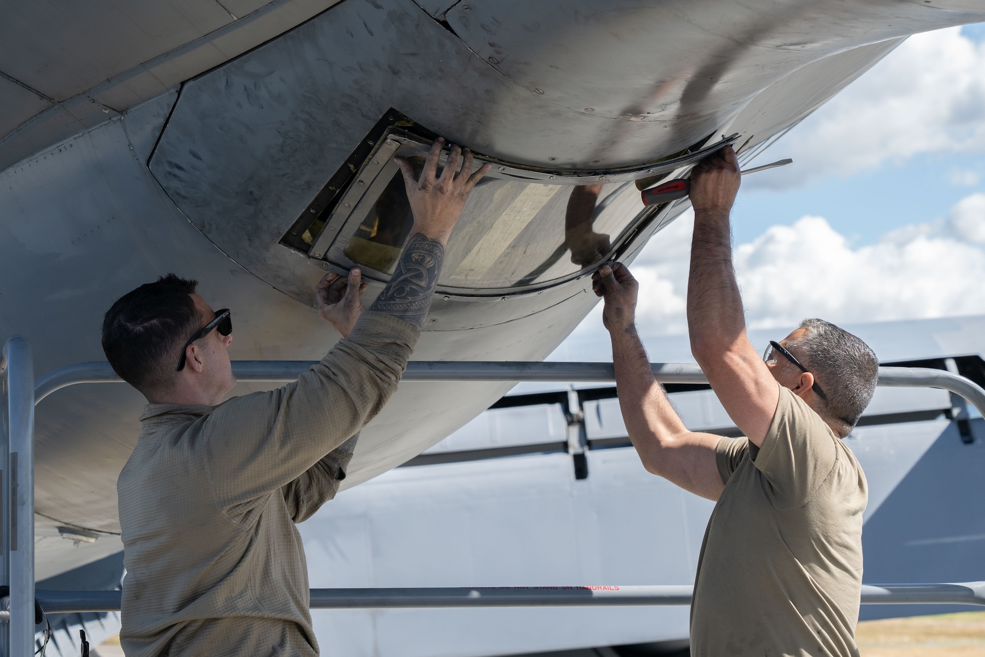 Airmen perform maintenance on an aircraft.