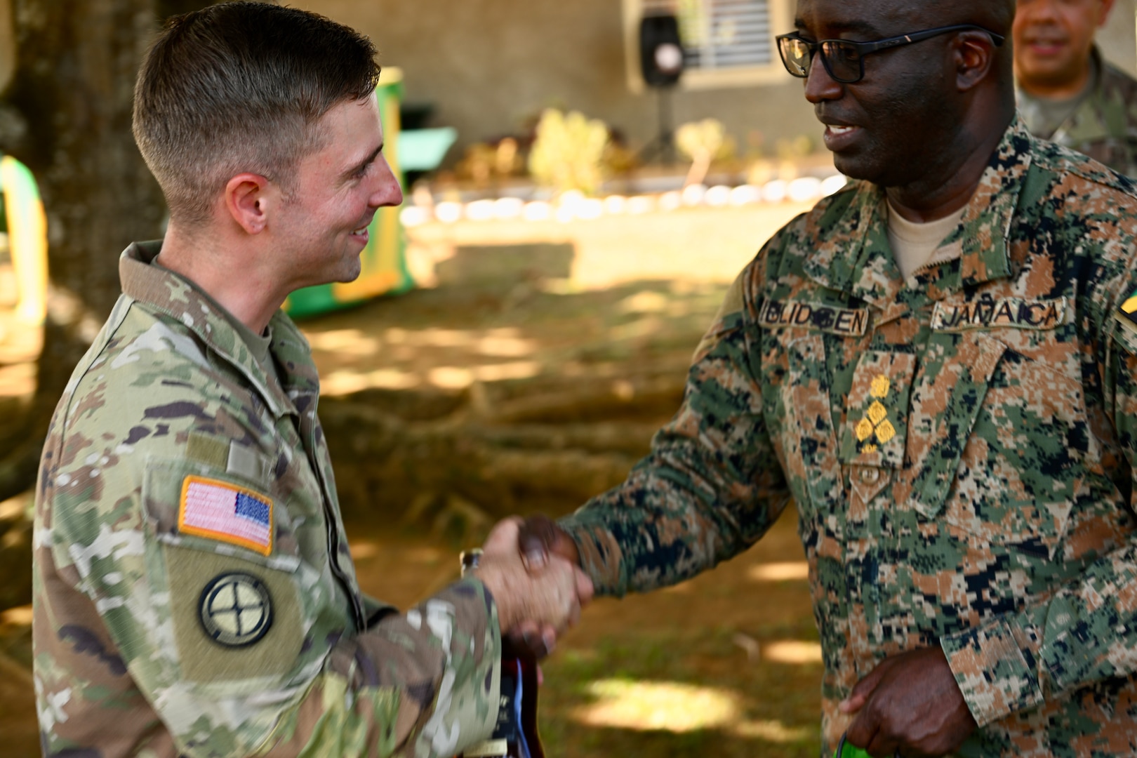 U.S. Army Capt. Aaron Lies, outgoing Bilateral Affairs Officer, greets Brig. Ricardo Blidgen, commander of the Jamaica National Reserve, during the Caribbean Regional Training Camp 2025, in Kingston, Jamaica, on July 18, 2025. Capt. Lies completed a two-year tour in Jamaica serving as a critical liaison facilitating military-to-military engagements and joint training, ensuring the continued strength of a long-standing partnership.