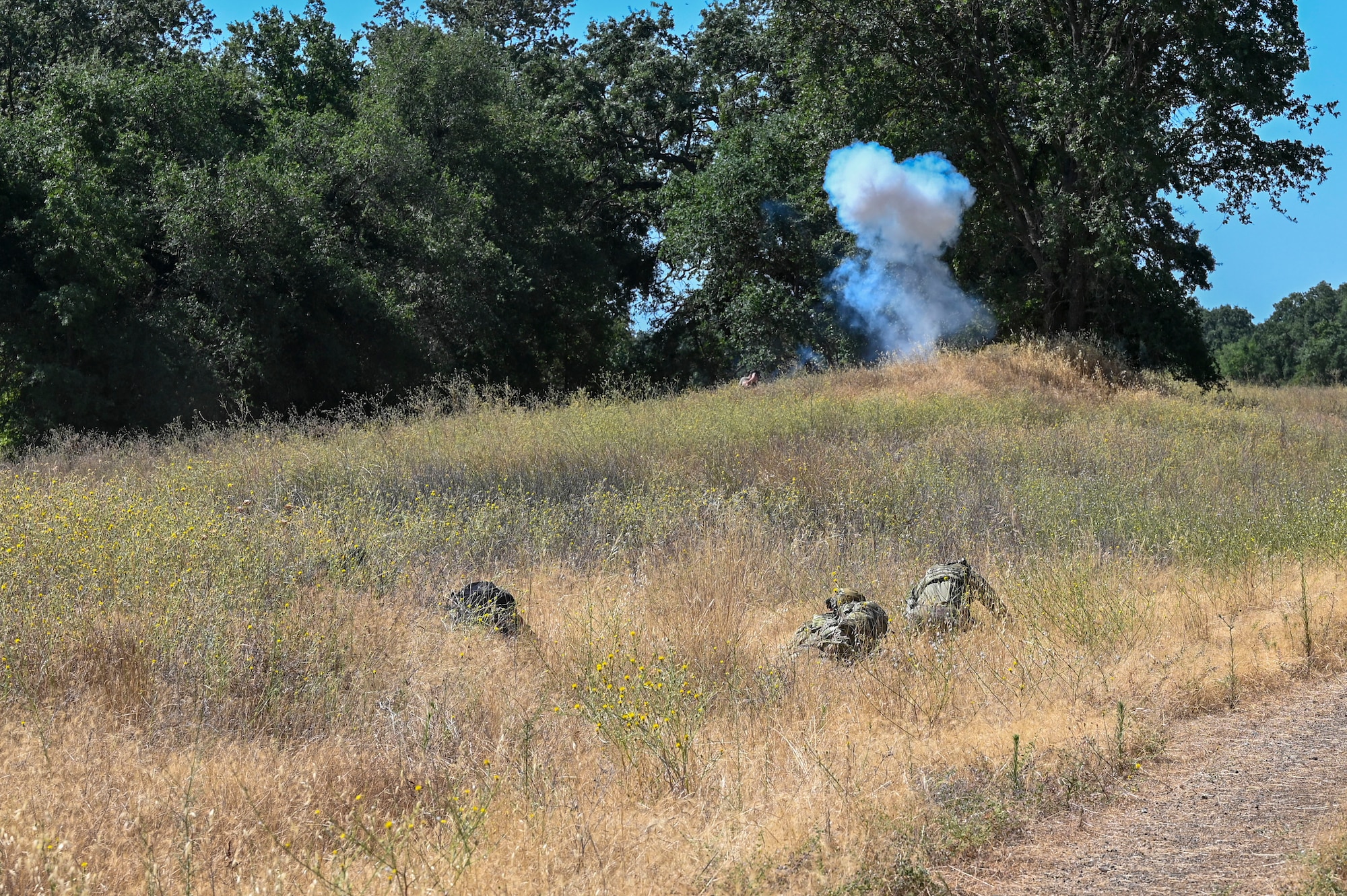 Airmen from the 9th Civil Engineer Squadron take cover from a controlled explosion during an exercise on Beale Air Force Base, California, July 17, 2025.