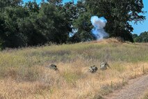 Airmen from the 9th Civil Engineer Squadron take cover from a controlled explosion during an exercise on Beale Air Force Base, California, July 17, 2025.