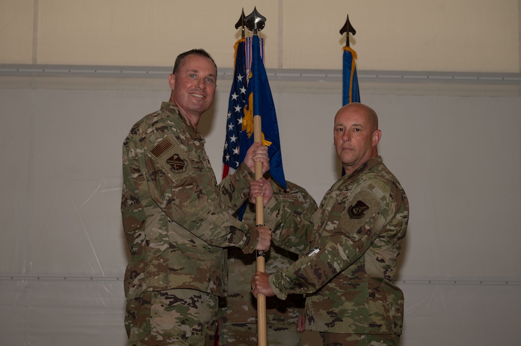 U.S. Air Force Col. Michael Mullin, 354th Fighter Wing deputy commander, passes the guidon to Col. Joseph Gilpin, 354th Maintenance Group incoming commander, during a change of command ceremony at Eielson Air Force Base, Alaska, July 24, 2025.