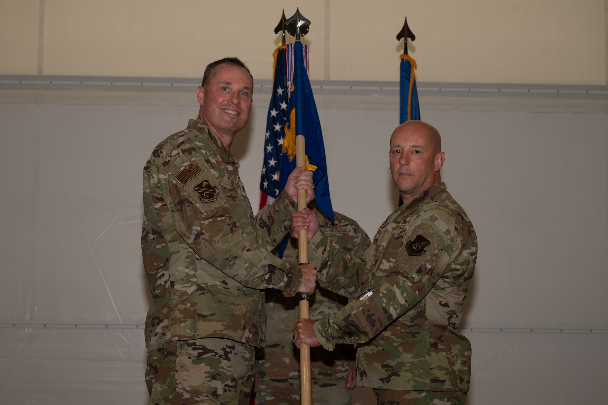 U.S. Air Force Col. Michael Mullin, 354th Fighter Wing deputy commander, passes the guidon to Col. Joseph Gilpin, 354th Maintenance Group incoming commander, during a change of command ceremony at Eielson Air Force Base, Alaska, July 24, 2025.