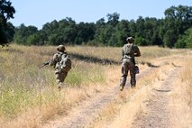U.S. Air Force Senior Airman James Xiong, 9th Civil Engineer Squadron fire fighter, and U.S. Air Force Staff Sgt. Terrell Phillips, 9th Civil Engineer Squadron pavement and heavy equipment supervisor, provides cover during an exercise on Beale Air Force Base, California, July 17, 2025.