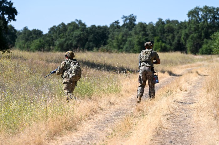 U.S. Air Force Senior Airman James Xiong, 9th Civil Engineer Squadron fire fighter, and U.S. Air Force Staff Sgt. Terrell Phillips, 9th Civil Engineer Squadron pavement and heavy equipment supervisor, provides cover during an exercise on Beale Air Force Base, California, July 17, 2025.