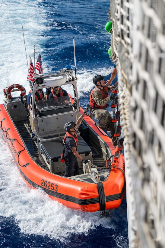 Cpl. Kenneth Lacy, a linguist for the U.S. Marine Corps, transits from the fantail of the medium endurance cutter USCGC Harriet Lane (WMEC 903) to a 26-foot over-the-horizon small boat in the Pacific Ocean June 9, 2025. The Harriet Lane crew conducted bilateral maritime law enforcement operations with the Cook Island Ministry of Marine Resources as part of Operation Nasse, a three-month operation conducted by Australia, France, New Zealand, and the U.S. to detect, deter, and disrupt illegal, unreported, and unregulated fishing on the high seas of the Pacific Ocean. (U.S. Coast Guard photo by Petty Officer 3rd Class Austin Wiley)
