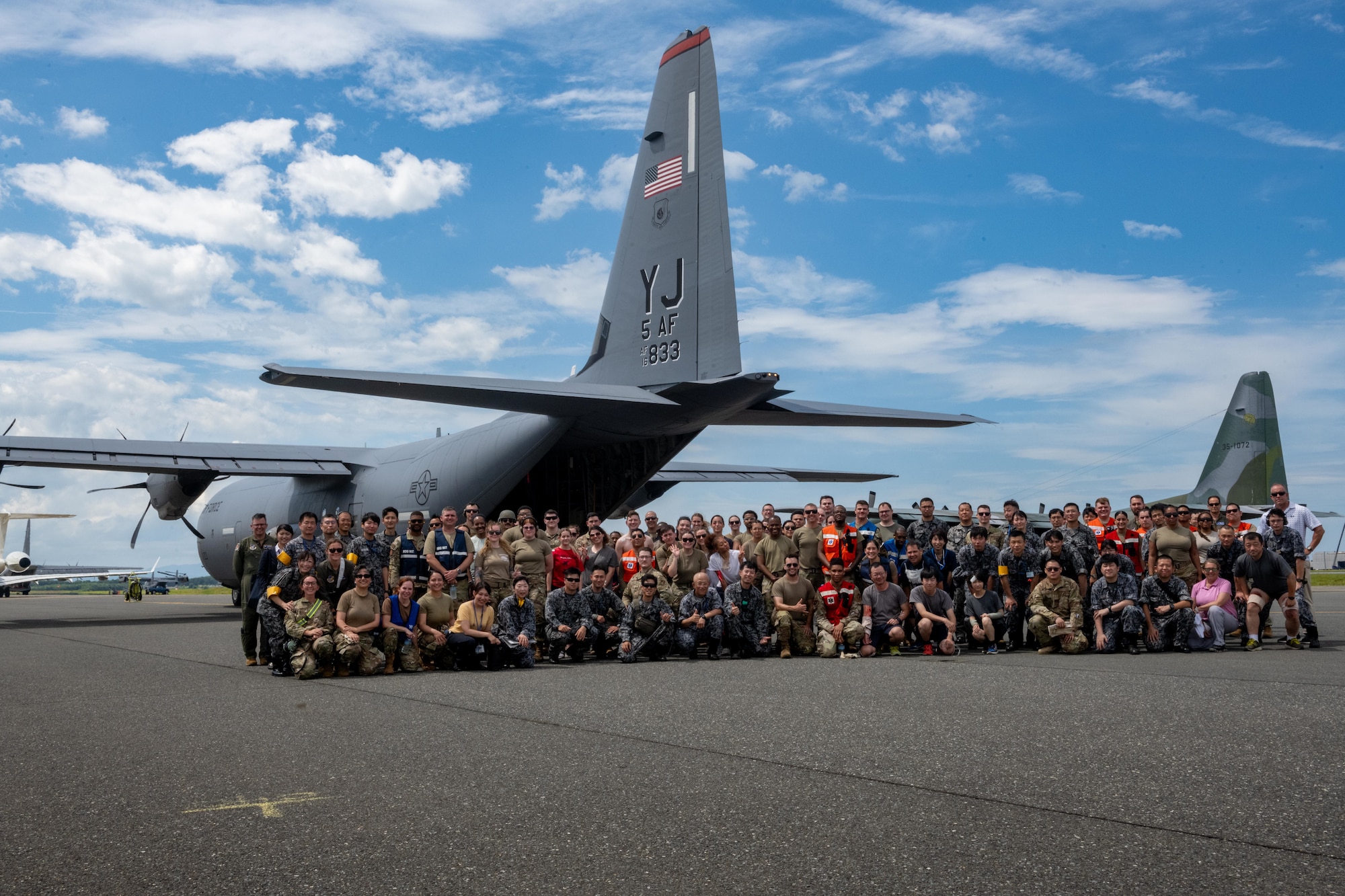 U.S. Air Force Airmen assigned to the 35th Fighter Wing and 18th Aeromedical Evacuation Squadron along with Japan Air Self-Defense Force airmen assigned to the 3rd Air Wing pose for a photo in front of a U.S. Air Force C-130J Super Hercules during exercise Resolute Force Pacific (REFORPAC) 2025.