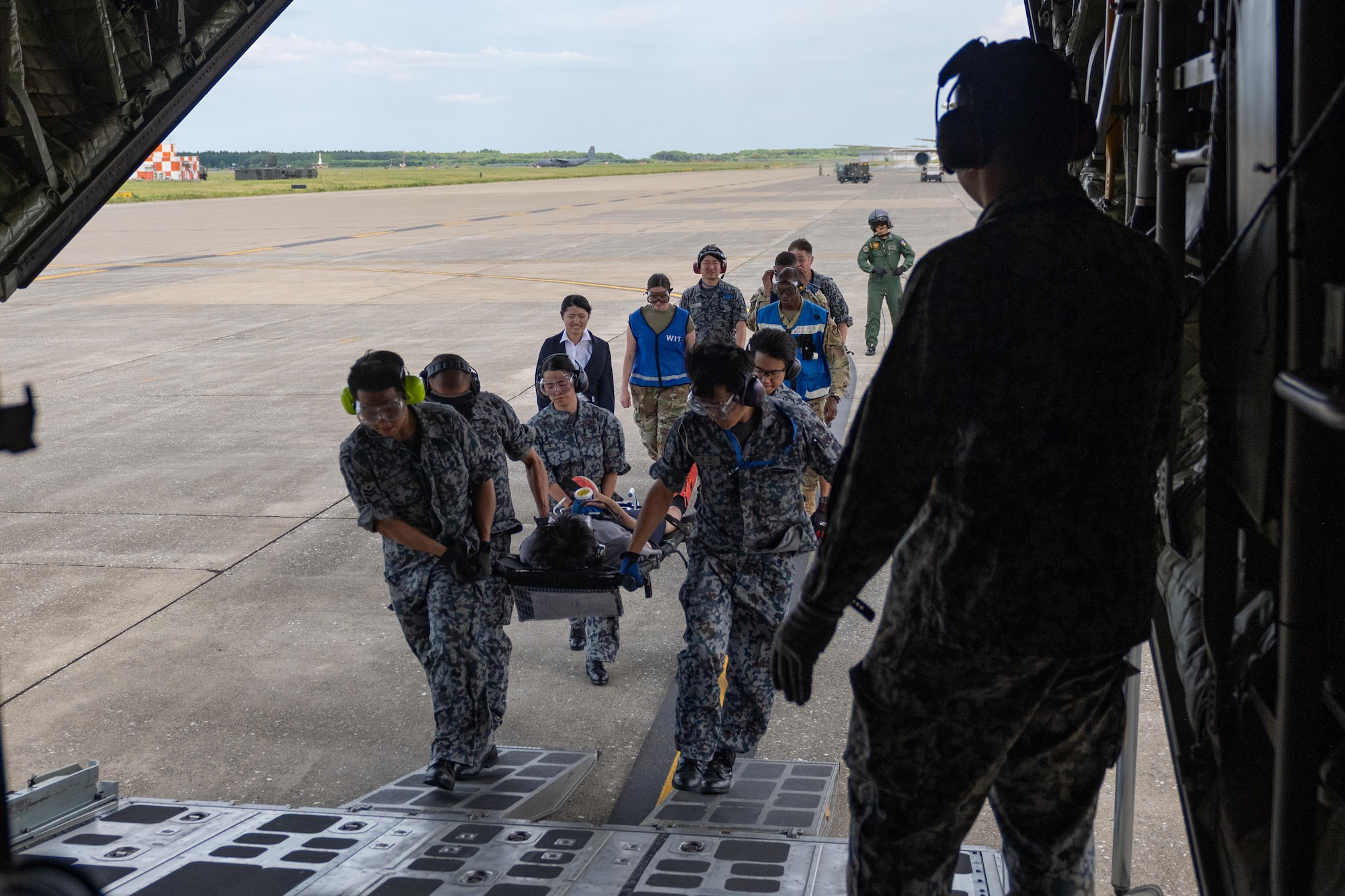 Japan Air Self-Defense Force airmen assigned to the 3rd Air Wing carry a simulated patient onto a JASDF C-130H Hercules during exercise Resolute Force Pacific (REFORPAC) 2025.
