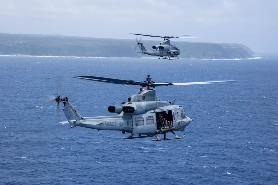 A U.S. Marine Corps UH-1Y Venom and an AH-1Z Viper helicopter with Marine Light Attack Helicopter Squadron 169, Marine Aircraft Group 36, 1st Marine Aircraft Wing fly off the coast of Okinawa, Japan, July 19, 2025.