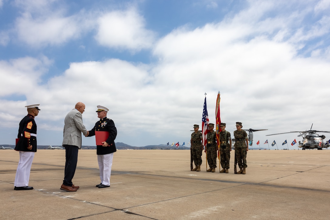 U.S. Marine Corps Col. Kevin G. Hunter, right, the former commanding officer of Marine Aircraft Group 16, 3rd Marine Aircraft Wing, receives a Certificate of Retirement from Retired U.S. Marine Corps Gen. David H. Berger, center, during Hunter’s retirement ceremony at Marine Corps Air Station Miramar, California, July 18, 2025. Throughout his 26 years of honorable service, Hunter demonstrated consistent excellence with more than 3,100 mishap-free flight hours. His achievements earned him numerous commendations, including the Legion of Merit; Defense Meritorious Service Medal; Meritorious Service Medal with two gold stars; Individual Action Air Medal; Air Medal with Strike Numeral XIV; Joint Service Commendation Medal; Navy Commendation Medal; Navy and Marine Corps Achievement Medal with one gold star; and the Presidential Service Badge. (U.S. Marine Corps photo by Lance Cpl. Samantha Devine)